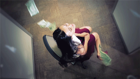 mulher girando em cadeira de escritório enquanto cédulas de dinheiro caem sobre ela
