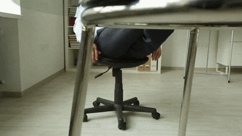 homem relaxando em cadeira de escritório com seus pés sobre a mesa